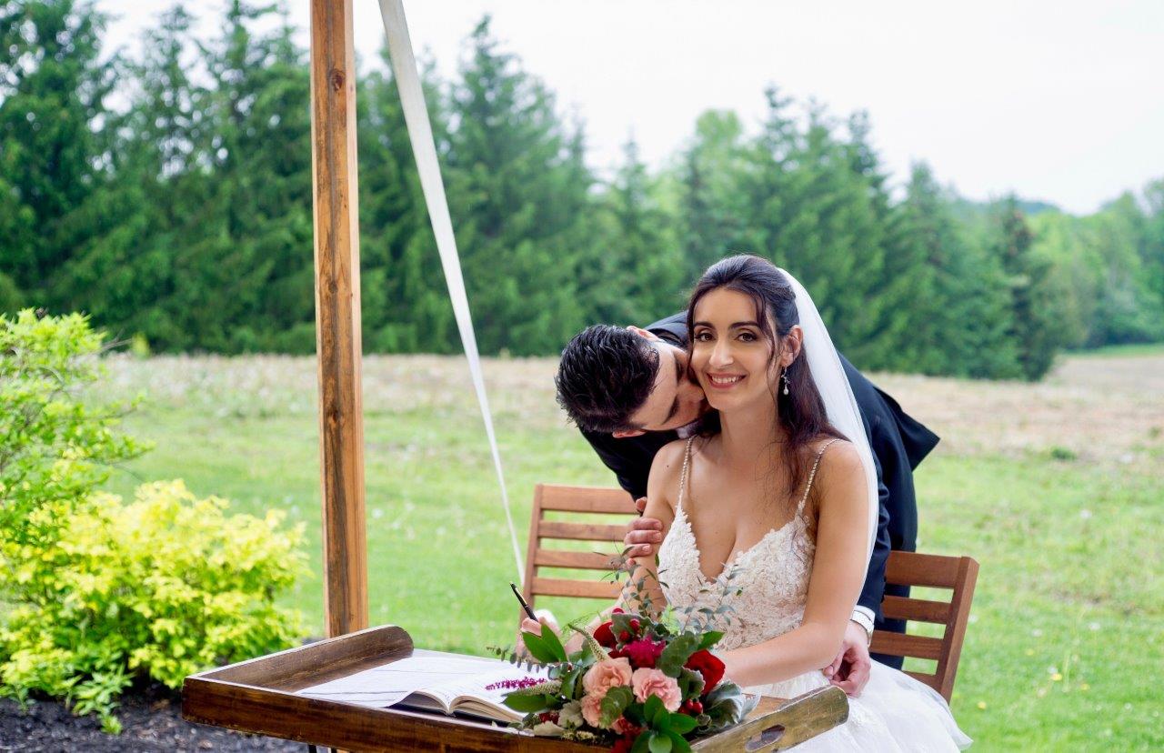 evermore weddings groom kissing bridge at registry table